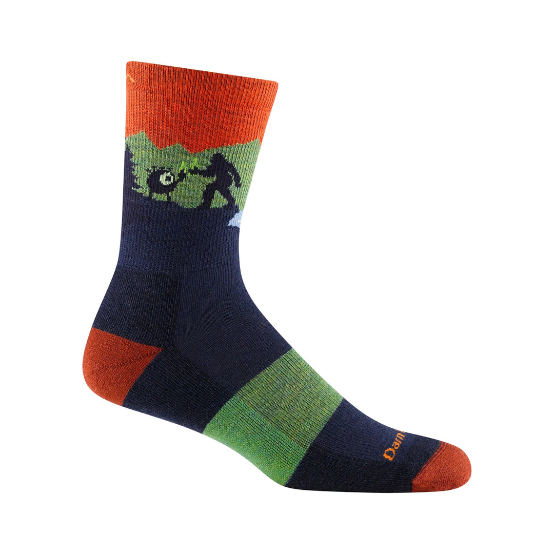 Colorful crew hiking sock with orange cuff, navy foot, green stripes, and a dinosaur graphic