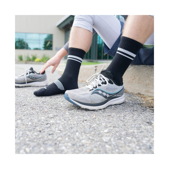 Black crew running sock with three white stripes near the calf, shown worn with a running shoe