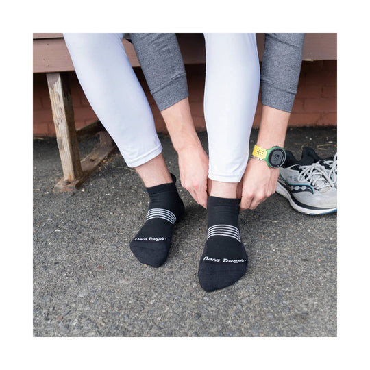 Black no-show tab running socks with three light stripes and visible logo text
