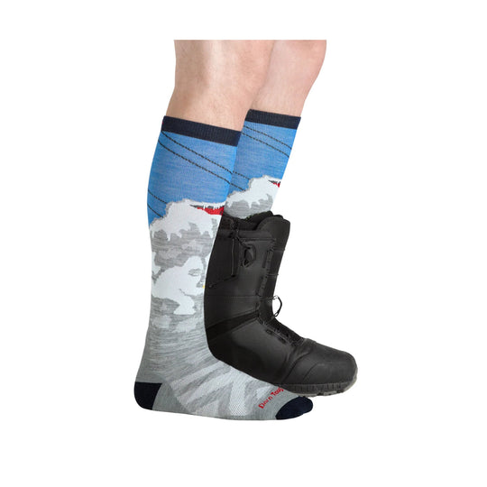 Gray and blue over-the-calf ski sock with mountain pattern, shown with a black snowboard boot
