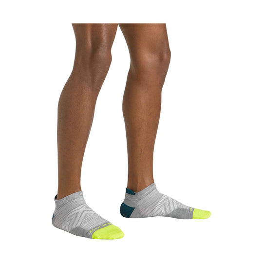 Gray no-show running socks with neon yellow toes and teal heel accents, shown on model's lower legs