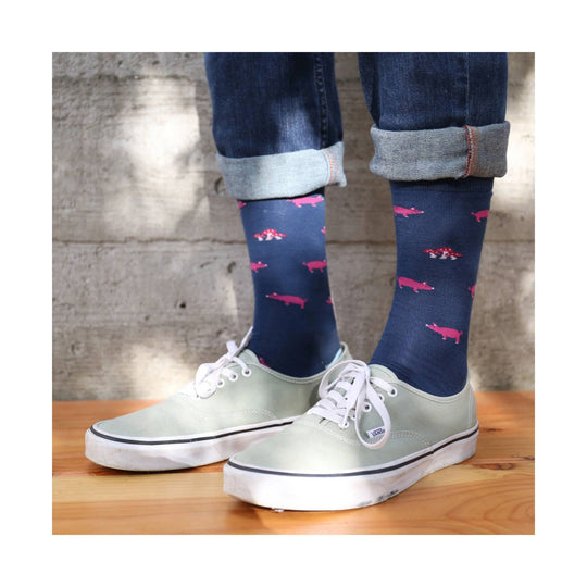 Navy socks with pink pig and mushroom pattern worn with cuffed jeans and pale green Vans sneakers