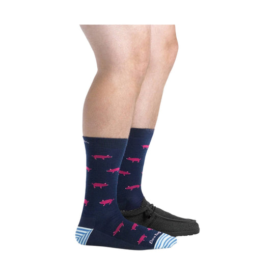 Navy crew socks with pink pig pattern and blue striped toes and heels worn with black shoes