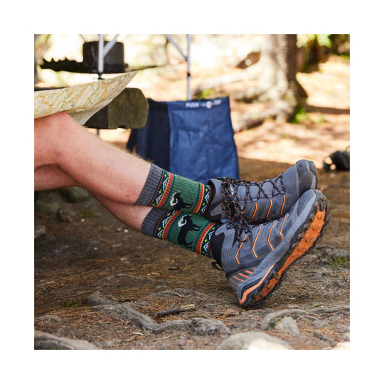 Gray and orange trail hiking shoes with green patterned hiking socks on a seated person outdoors