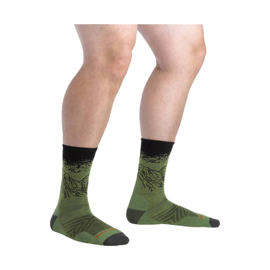 Green crew socks with black cuffs, heels, and toes, shown on a model’s lower legs.