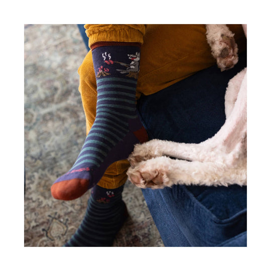 Purple and teal striped crew sock with a wolf and campfire pattern
