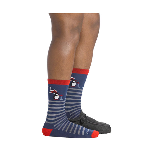 Navy crew socks with red cuffs and toes, gray stripes, and penguin graphics on a model’s lower legs