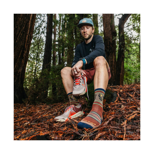 Striped lightweight hiking socks with cactus and trail icons, shown with trail shoes.