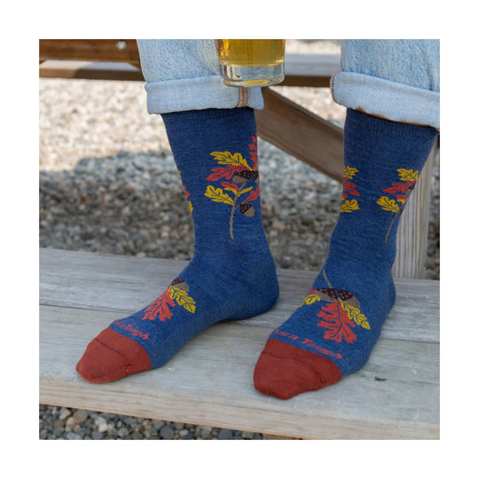 Blue crew socks with red toes and heel, featuring colorful autumn leaf and acorn patterns.