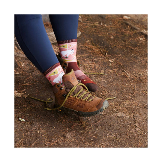 Patterned pink-and-burgundy hiking socks worn with brown hiking boots on a dirt trail