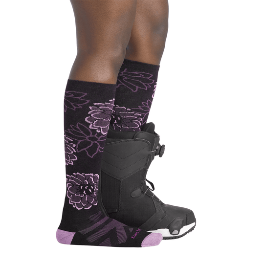 Black knee-high ski socks with purple floral pattern, shown with black snowboard boots