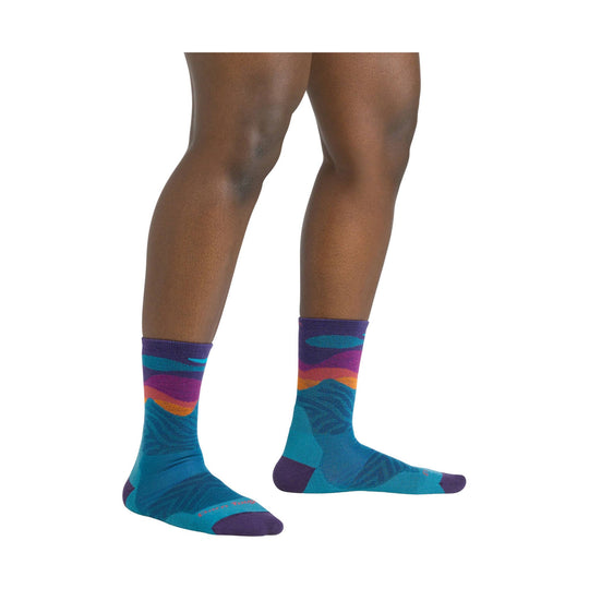 Purple, teal, and orange patterned crew running socks on a model’s lower legs