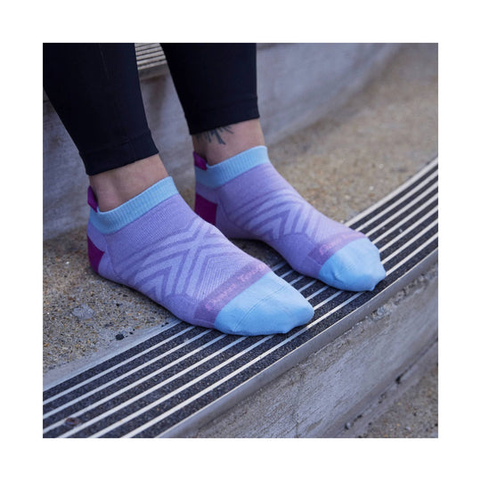 Lavender and light blue no-show running socks on feet