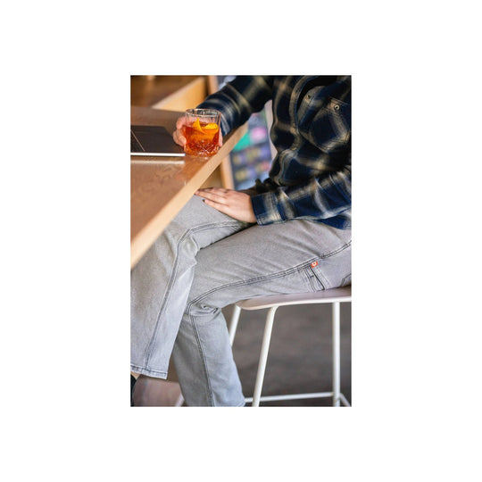 Light gray work pants on a seated model, shown with a side pocket and reinforced seams