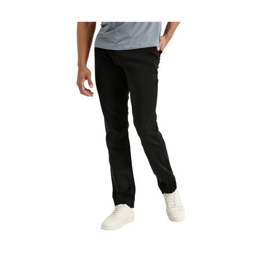 Black slim-fit pants with tapered legs, shown on a model with white sneakers