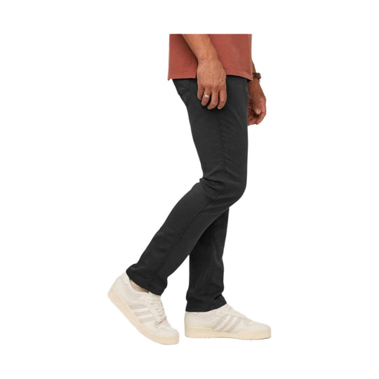 Black relaxed-taper pants with a straight leg, shown on a model with white sneakers