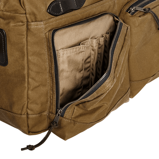 Tan canvas duffel bag with an open zippered exterior pocket and interior organizer slots
