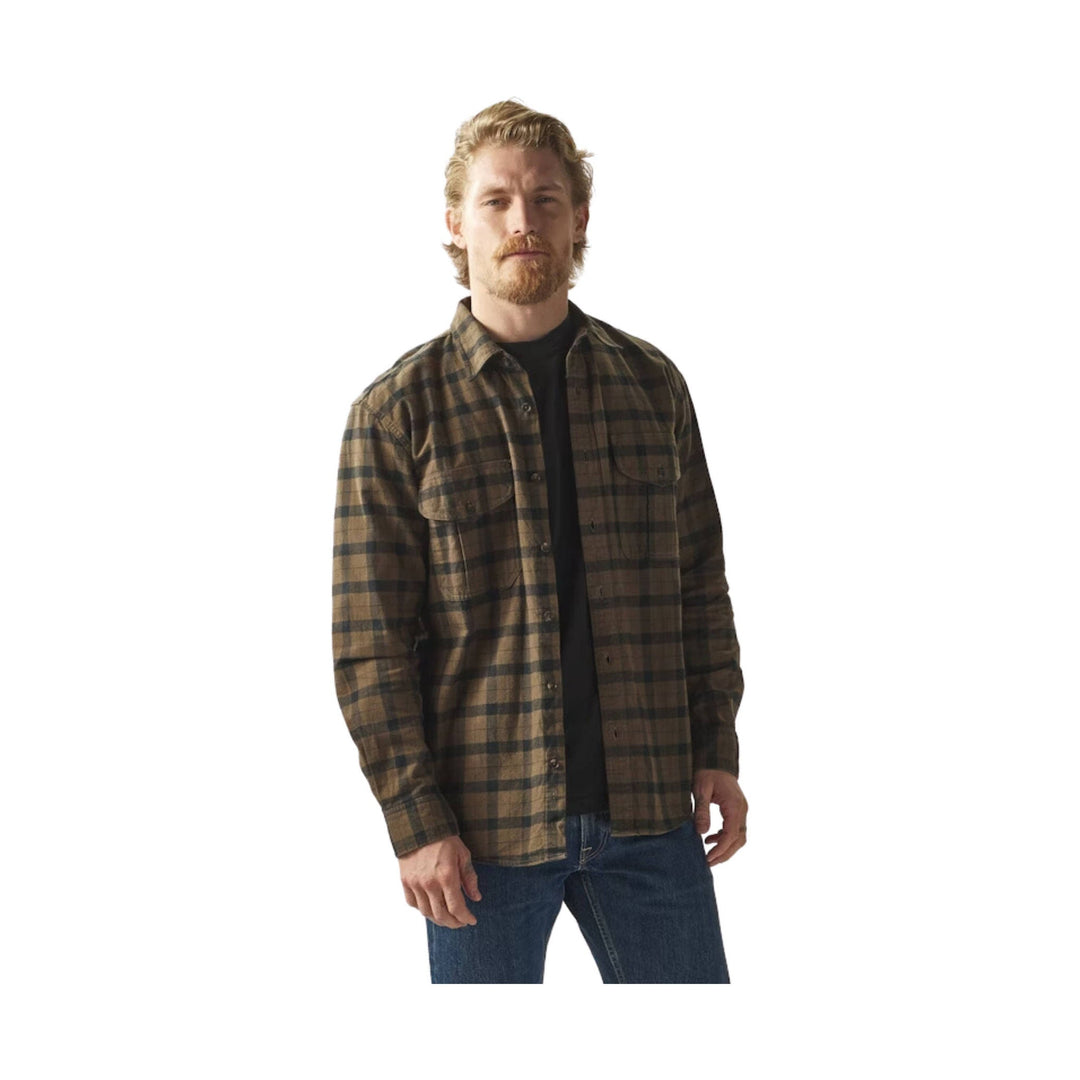 Brown and black plaid button-up shirt worn over a black T-shirt with blue jeans