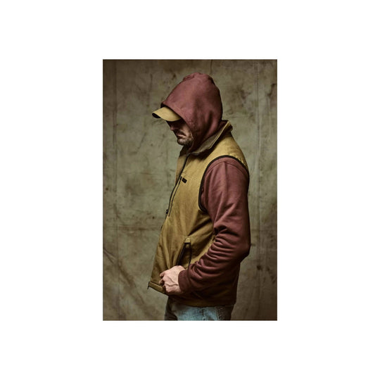 Side view of a tan and burgundy insulated vest worn over a hoodie and cap