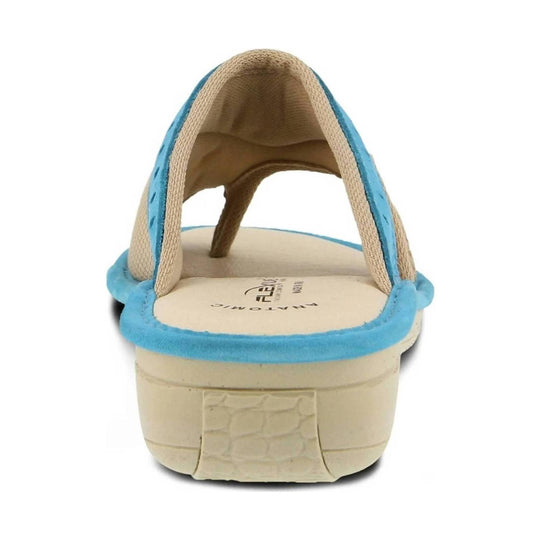 Blue and beige slide sandal viewed from the back, with woven straps and a cushioned footbed.