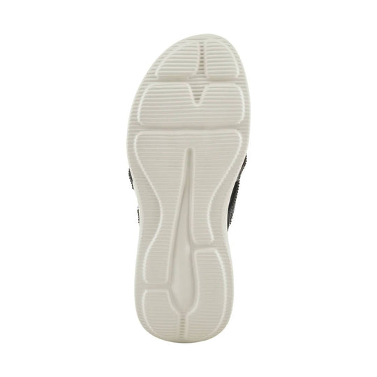 Bottom view of a black sandal with a white grooved outsole