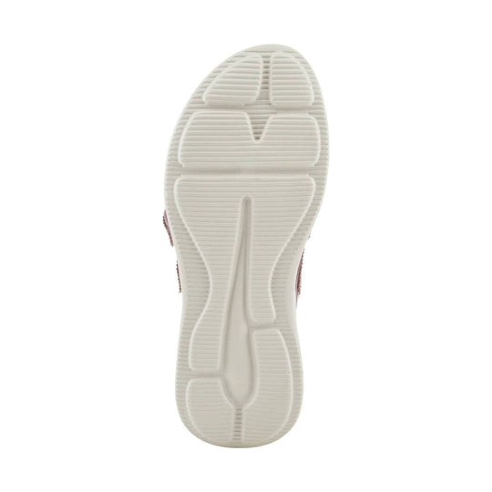 White outsole of a women’s sandal with textured tread and molded cushioning grooves