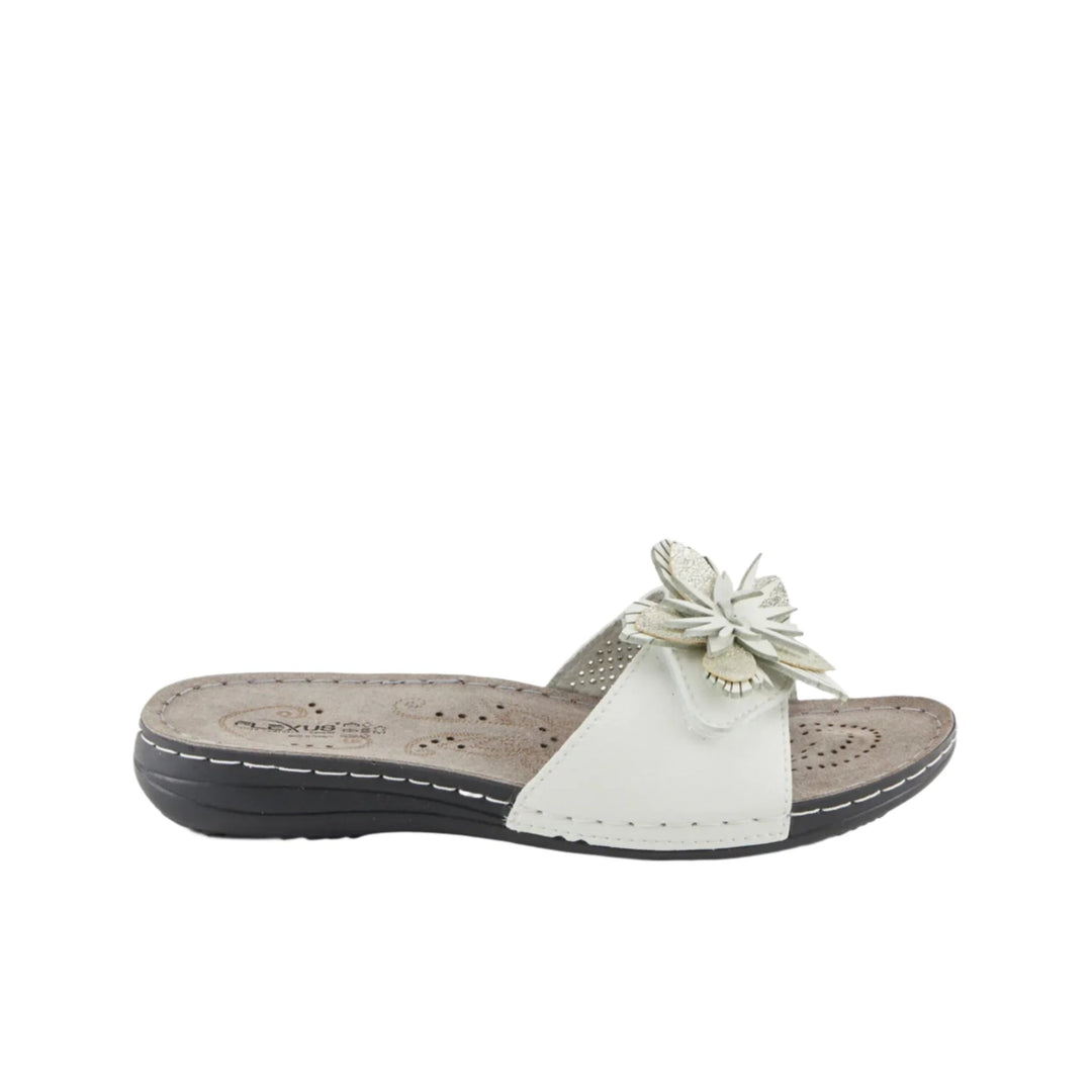 White slide sandal with floral applique on the strap and a low wedge sole