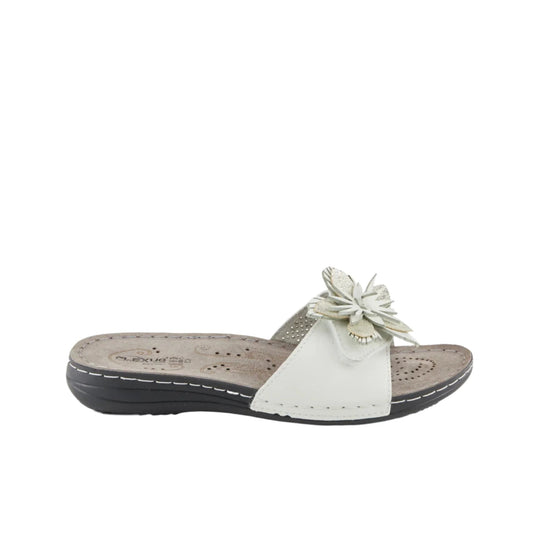 White slide sandal with floral applique on the strap and a low wedge sole