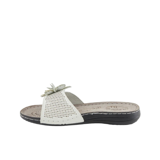 White wedge slide sandal with perforated strap and floral embellishment, shown in side view