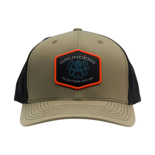 Tan and black trucker hat with a hexagonal front patch and orange trim