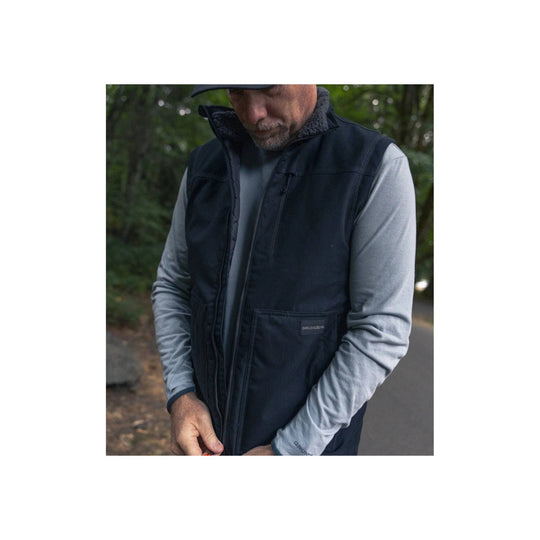 Dark zip-front insulated vest over a gray long-sleeve shirt, with a chest pocket and small logo patch