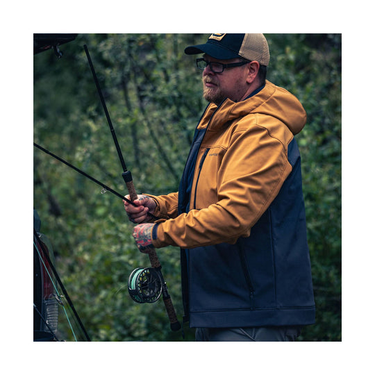 Two-tone hooded fishing jacket in tan and navy, shown on a man holding a fishing rod outdoors