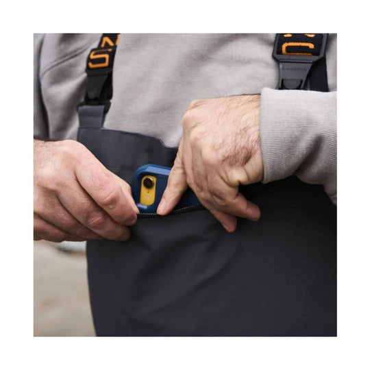 Black bib overalls with shoulder straps, shown close up as someone adjusts the waistband