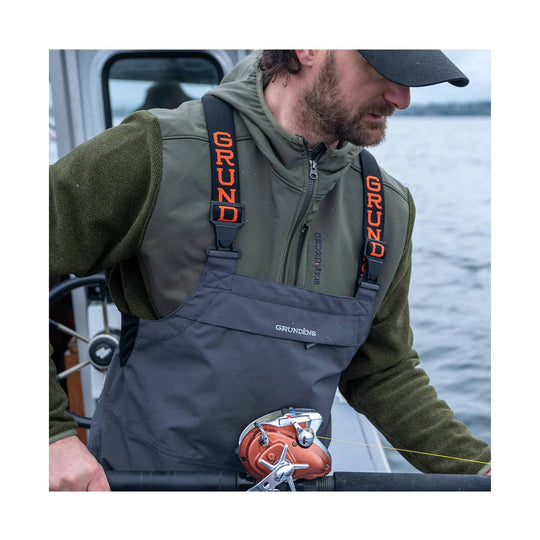 Dark waterproof fishing bib pants with orange GRUNDENS suspenders