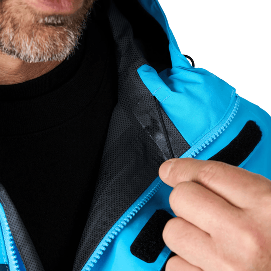 Close-up of a blue and black hooded waterproof jacket being held open to show the inner lining