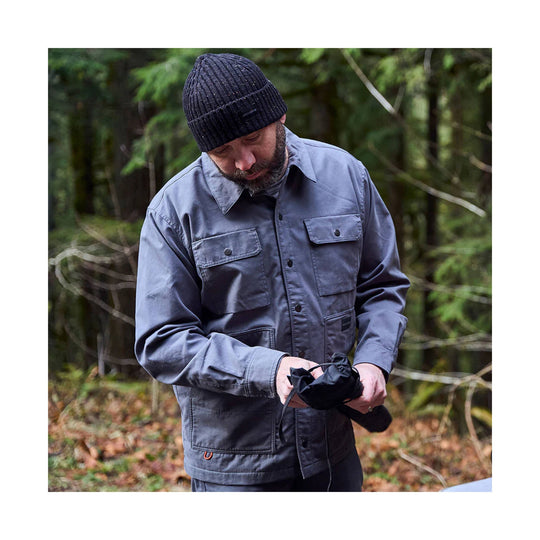 Gray button-up shacket with chest flap pockets, worn outdoors by a man holding a folded black umbrella