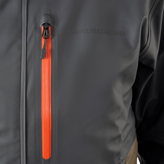 Dark gray waterproof jacket with a bright orange front zipper and GRUNDENS logo