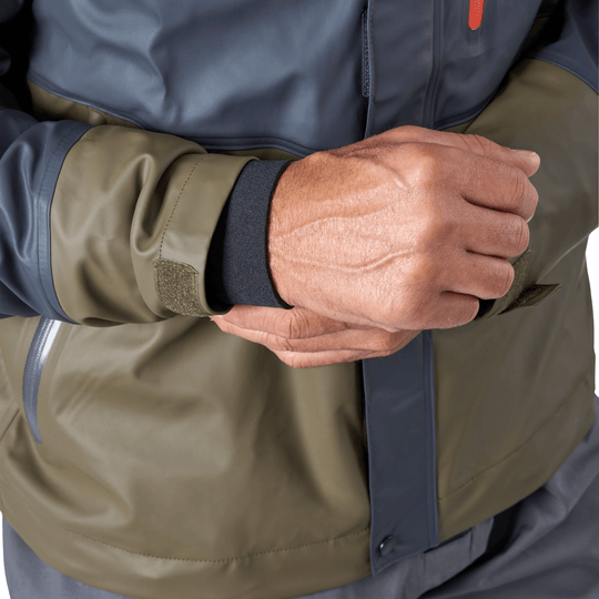 Close-up of a gray and olive waterproof jacket with a zip front and cuffed sleeves, hands clasped in front