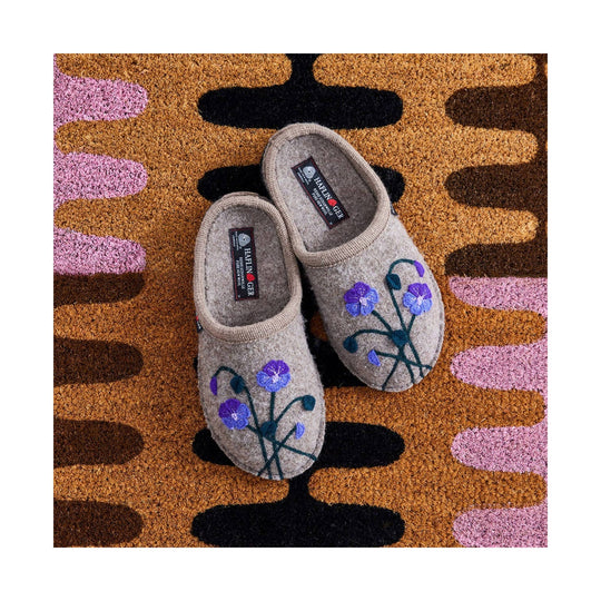 Gray felt slippers with embroidered purple flowers, shown pair on a patterned rug