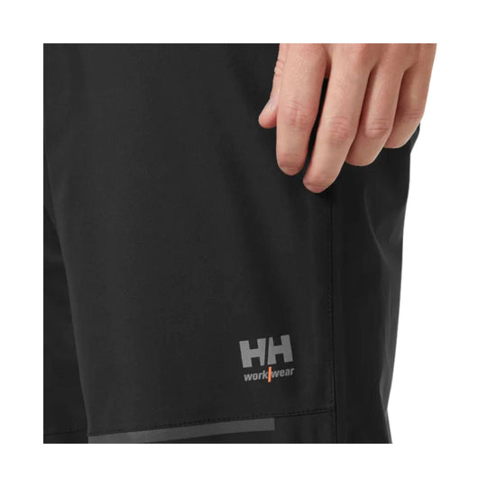 Black work pants with HH workwear logo near the hem and a vertical side seam