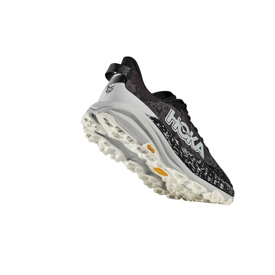 Black and white trail running shoe with aggressive lugged sole and side logo