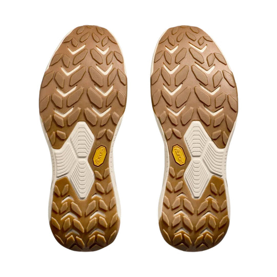 Pair of brown and tan hiking shoe outsoles with aggressive tread and white midfoot panels