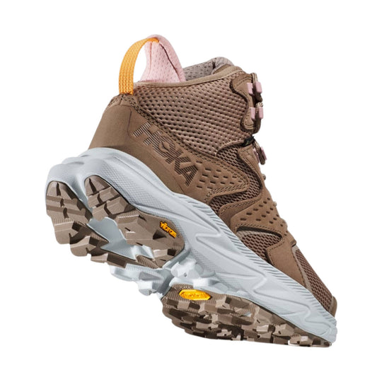 Brown mid-top hiking shoe with HOKA logo, mesh panels, pull tab, and lugged outsole
