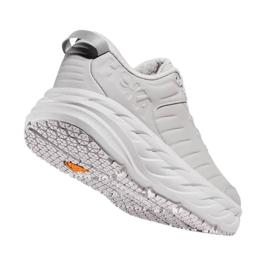 Light gray athletic shoe with thick cushioned sole, side branding, and treaded outsole shown from below