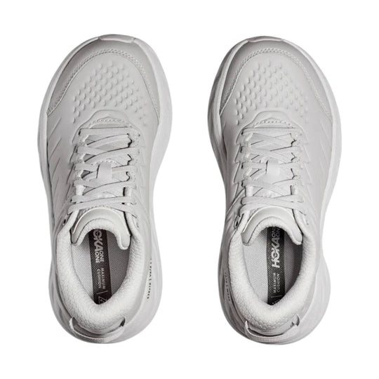 White low-top athletic sneakers with laces, cushioned collars, and textured toe boxes