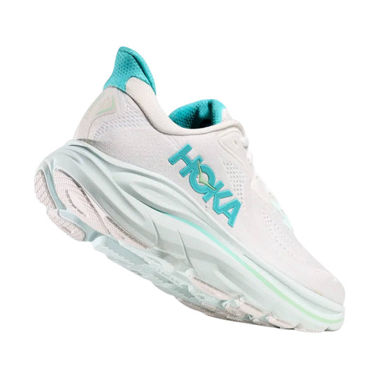 White running shoe with turquoise accents and HOKA logo on the side, shown from the rear side.