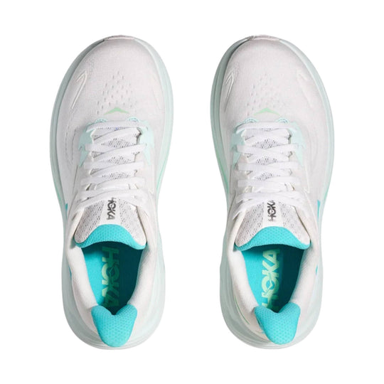 Pair of white running shoes with turquoise accents, shown from above