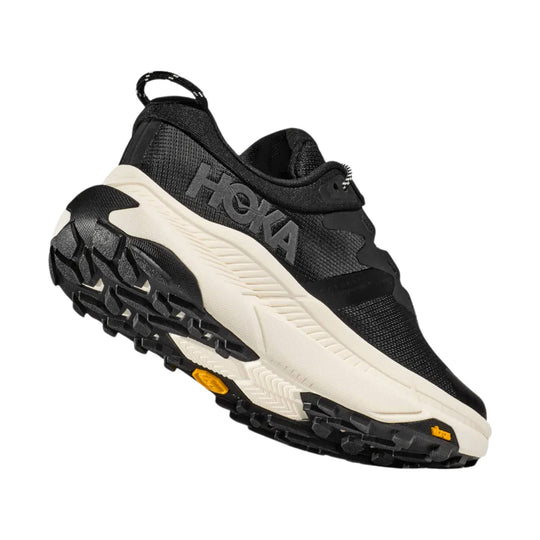 Black trail shoe with a cream midsole and rugged lugged outsole, shown in side view
