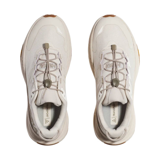 Pair of cream low-top hiking shoes with bungee laces and thick soles, viewed from above
