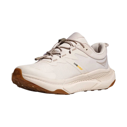 Light beige low-top trail shoe with bungee laces, padded collar, and brown rubber outsole